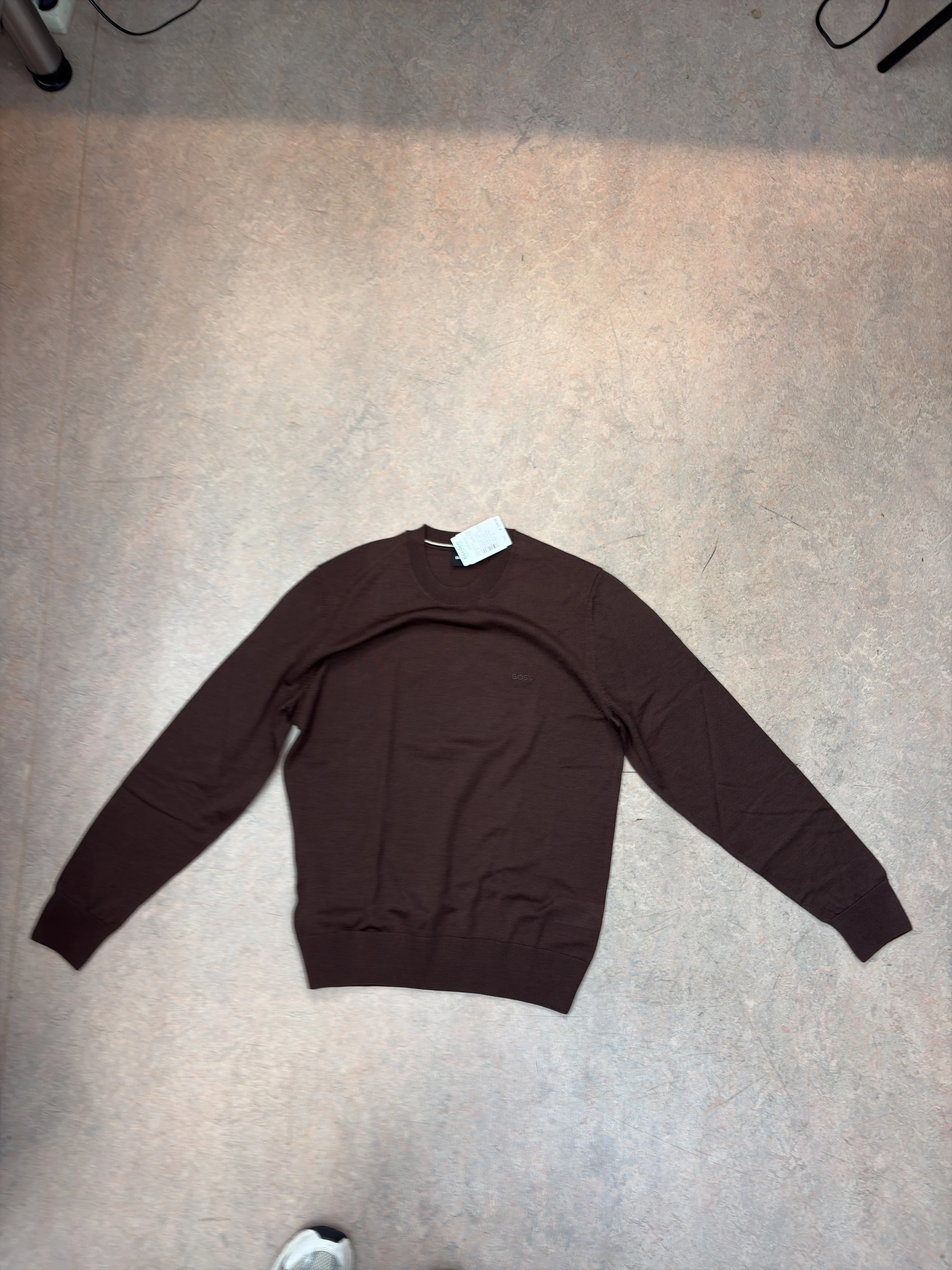 Sweater flat on the floor, photographed with a phone