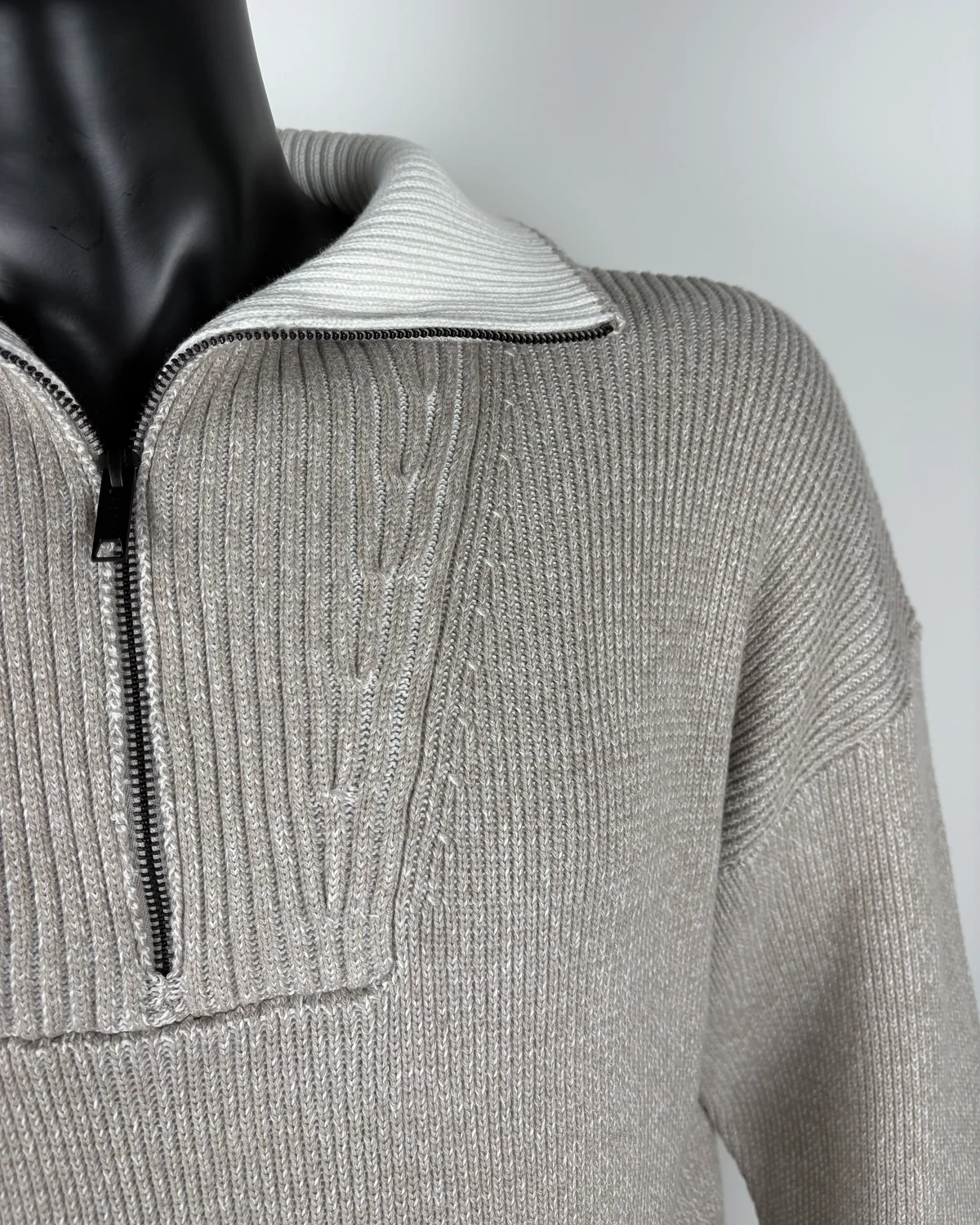 Close-up of the zip and the white ribbed collar of the same sweater