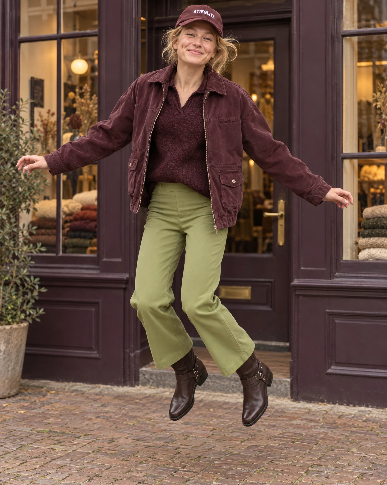 The same look mid-jump, in front of a shop window