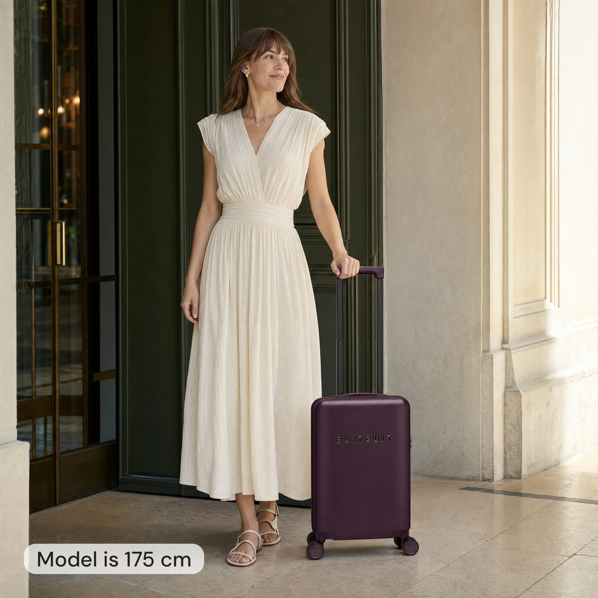 AI model image: woman 175 cm tall next to a burgundy Suitsuit carry-on suitcase 54 cm high