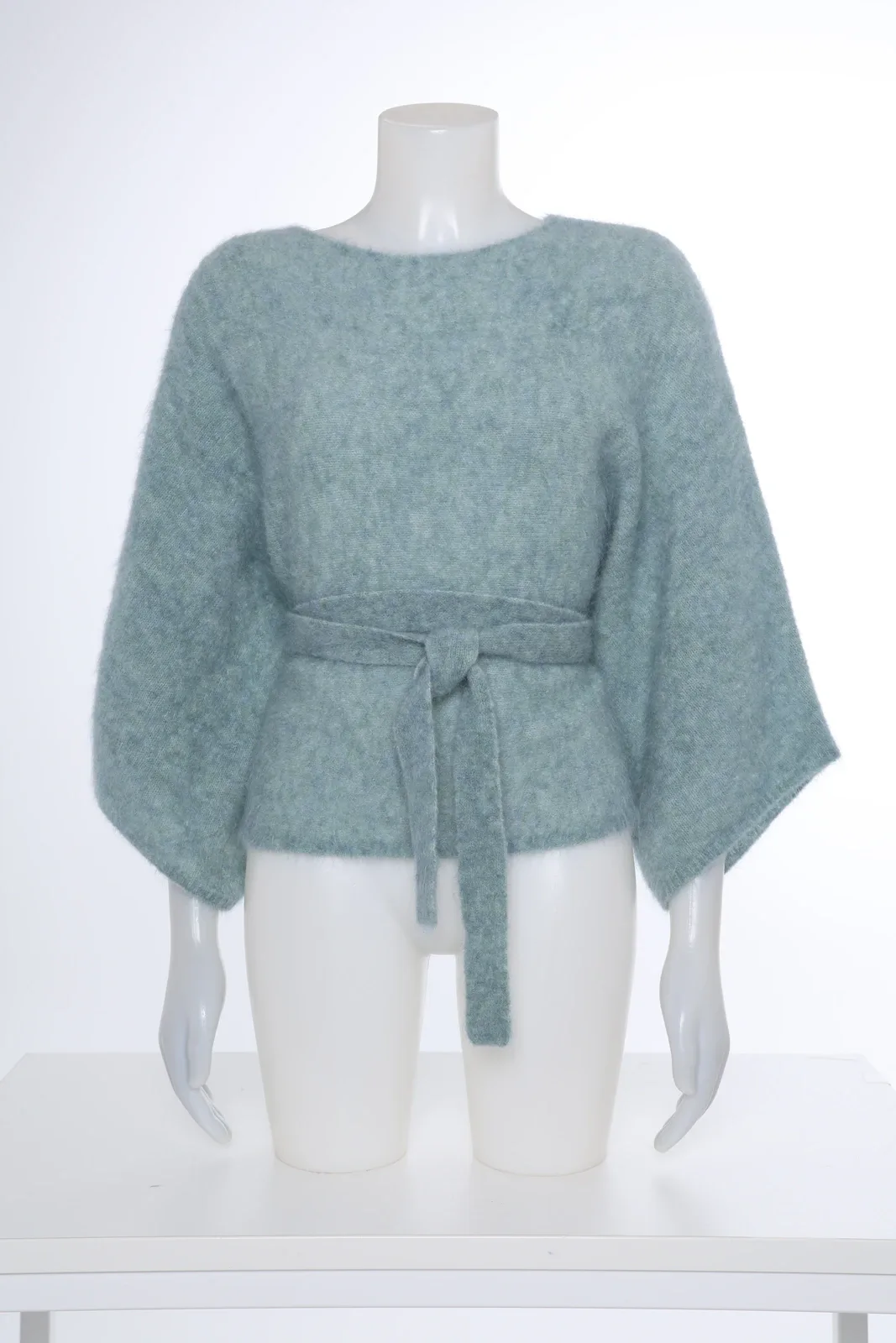 Mint green knitted top with bow belt on a mannequin
